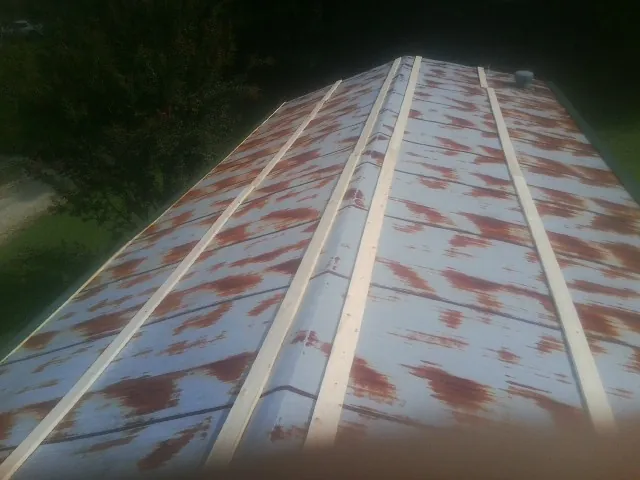 Rusted metal roof panels with new wood purlins before replacement — Storm Damage Roof Repair in Dodge by Roofing Brothers