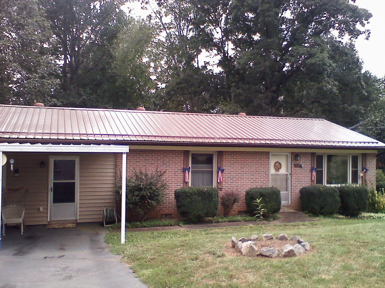 Bronze metal roof and carport on a brick ranch home — Roof Repair work by our crew in Dodge