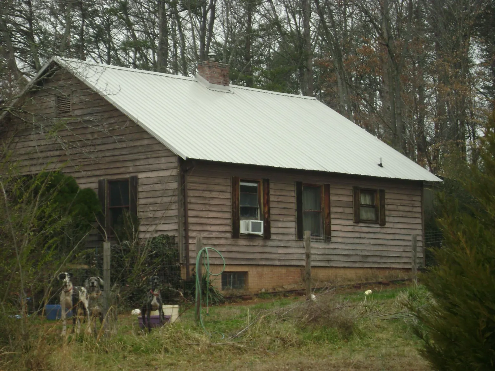 White metal roof on an old wood sided farmhouse, from a Metal Roof Installation job in Dodge